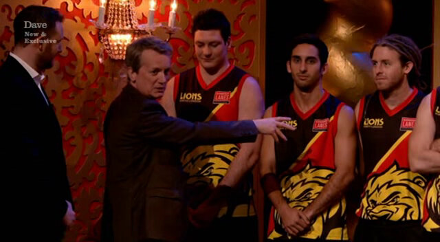 Image of Frank Skinner trying to correctly introduce three members of an Australian Rules Football team. Image of Frank Skinner trying to correctly introduce three members of an Australian Rules Football team.
