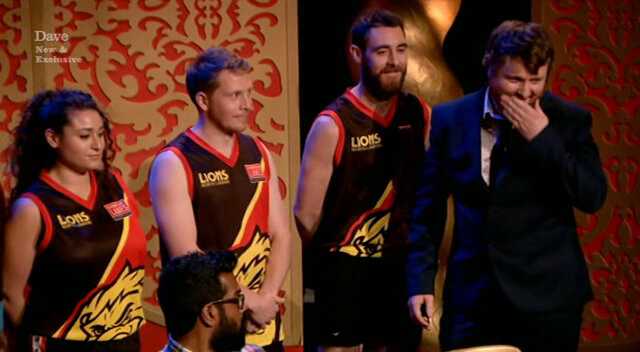 Image of Tim Key trying to correctly introduce three members of an Australian Rules Football team (and failing to keep a straight face at the name ‘Yank Tank’). Image of Tim Key trying to correctly introduce three members of an Australian Rules Football team (and failing to keep a straight face at the name ‘Yank Tank’).