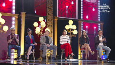 Image of the panel of contestants seated on stage together during this episode.
