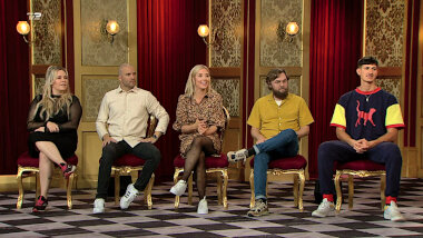 Image of the panel of contestants seated on stage together during this episode.