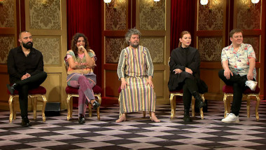Image of the panel of contestants seated on stage together during this episode.