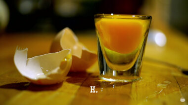 Image of the two halves of an egg shell, and its contents in a shot glass (presumably a reference to the two tasks in the episode involving eggs), with the episode title, 'H', superimposed on it.