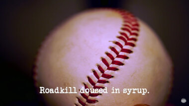 Image of a baseball (presumably a reference to the balls used during the 'Knock the bails off the stumps' task), with the episode title, 'Roadkill doused in syrup', superimposed on it.