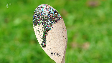 Image of a wooden spoon with glitter covering the end of it (a reference to Ardal O'Hanlon's attempt at the 'Show off' task), with the episode title, 'Heg', superimposed on it.