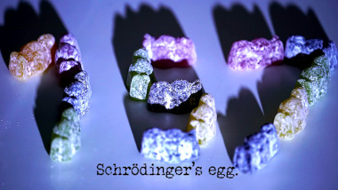 Photo of some jelly babies arranged to form the digits for the number 157 (a reference to the 'Free yourselves and have a team hug' task, and the season and episode numbers), with the episode title, 'Schrödinger's egg', superimposed on it.