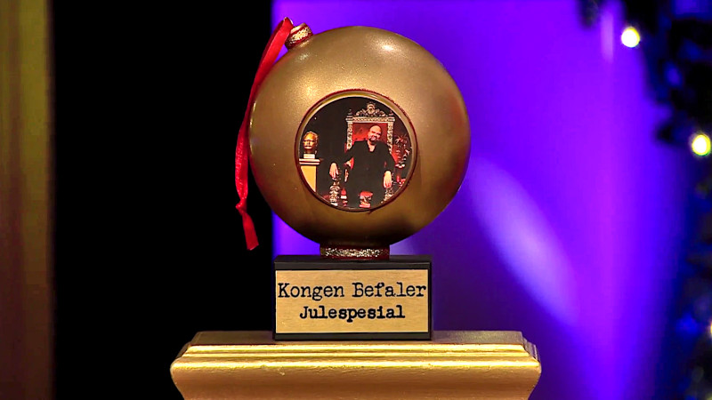 Image of the Kongen Befaler Christmas Special 2022 prize, a large golden bauble featuring a picture of Atle Antonsen on his throne. Image of the Kongen Befaler Christmas Special 2022 prize, a large golden bauble featuring a picture of Atle Antonsen on his throne.