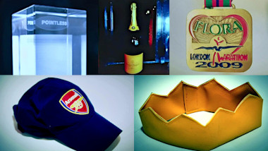 A composite of five images (top-left to bottom-right): a glass trophy from the TV show Pointless; a very large bottle of champagne; a finisher's medal from the 2009 London Marathon; an Arsenal FC branded baseball cap; and a Christmas cracker crown made out of leather.