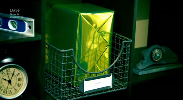 Image of a gift wrapped in shiny gold paper, in a pigeonhole in the Taskmaster house. Image of a gift wrapped in shiny gold paper, in a pigeonhole in the Taskmaster house.