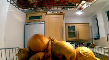 Close-up image of a pile of onions in a vegetable rack in the Taskmaster kitchen.