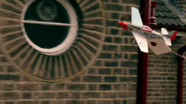Sealed task brief attached to a model aeroplane in flight.