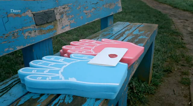 Four large foam hands, two blue and two red, placed on a park bench with a sealed task brief bridging the two sets of hands. Four large foam hands, two blue and two red, placed on a park bench with a sealed task brief bridging the two sets of hands.