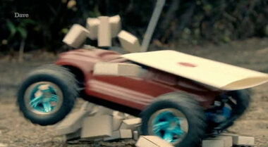 A remote controlled car carrying a sealed task brief crashes through a block tower.