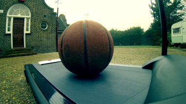 A basketball and a sealed task brief resting on a treadmill.