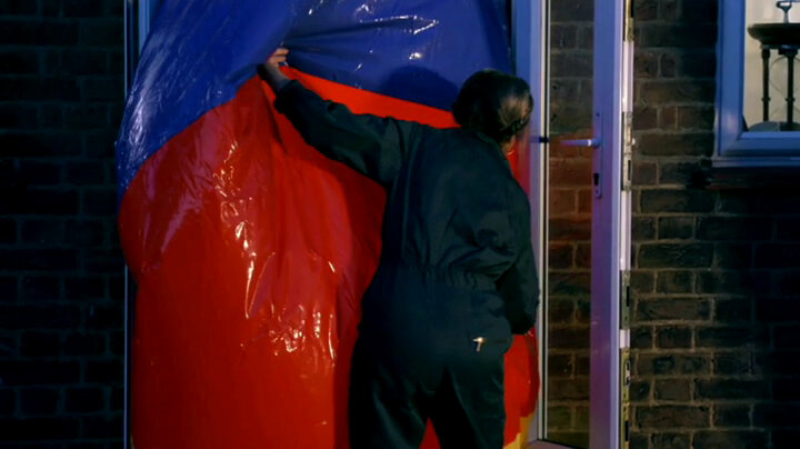 Mel Giedroyc works to get a giant beach ball through a doorway. Mel Giedroyc works to get a giant beach ball through a doorway.