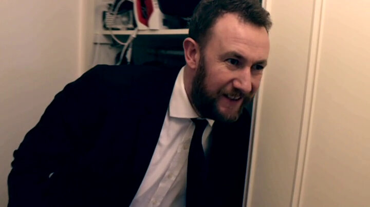 Alex Horne reaching into a closet in the Taskmaster house perpetrating a drive-by. Alex Horne reaching into a closet in the Taskmaster house perpetrating a drive-by.