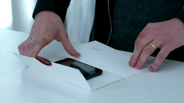 Mark Watson's hands opening a task in the lab. A cell phone rests inside the task.