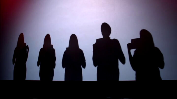 Silhouettes of five people standing in a row each holding a paper. Silhouettes of five people standing in a row each holding a paper.