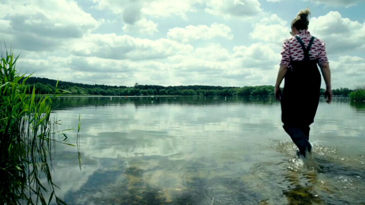 Sally Phillips walking out into a lake wearing fishing waders. Sally Phillips walking out into a lake wearing fishing waders.
