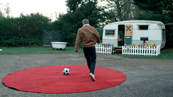 Russell Howard prepares to kick a football which is sitting in the centre of a red green. Russell Howard prepares to kick a football which is sitting in the centre of a red green.