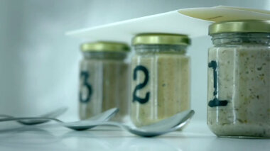 A sealed task brief resting on three sealed glass jars in the lab. The jars are labelled 3, 2 and 1. Each jar has a spoon resting in front of it.