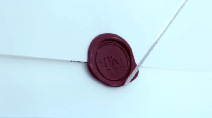 A close-up of the seal on a task. There is a string coming out from under the seal. A close-up of the seal on a task. There is a string coming out from under the seal.