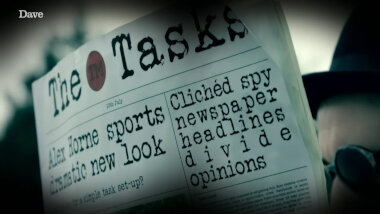 A close-up of a prop newspaper. The name of the paper is 'The Taskmaster'. It's dated 10th July. There are two stories on the front page of the paper: 'Alex Horne sports dramatic new look ' and 'Clichéd spy newspaper headlines divide opinions'. Part of another line reads '... a simple task set-up?'.