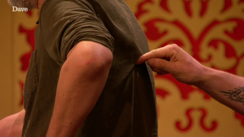 A close-up of David Baddiel's left side and arm. Ed Gamble is drawing on David's back with a finger. A close-up of David Baddiel's left side and arm. Ed Gamble is drawing on David's back with a finger.