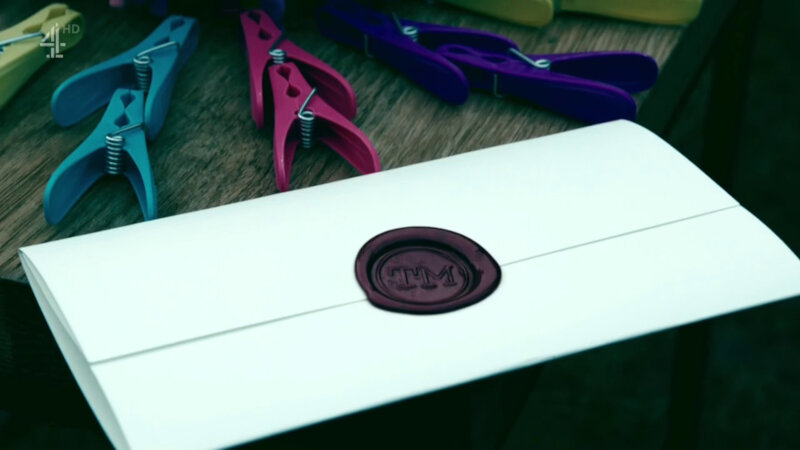 A sealed task next to a number of brightly coloured clothes pegs. They are yellow, purple, blue and pink. A sealed task next to a number of brightly coloured clothes pegs. They are yellow, purple, blue and pink.