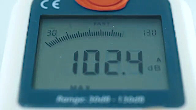 A close-up of a decibel meter. It reads 102.4 dB. A close-up of a decibel meter. It reads 102.4 dB.