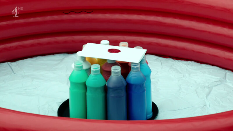 A sealed task brief rests of several bottles of paint in the centre of an inflated outdoor pool. A sealed task brief rests of several bottles of paint in the centre of an inflated outdoor pool.