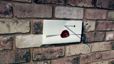 A sealed task brief nailed to a faux-brick wall.
