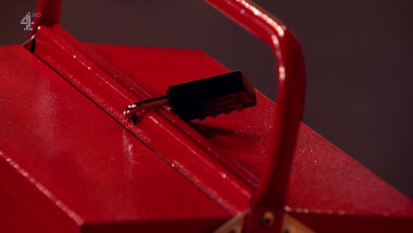 A padlock sealing a red metal toolbox.