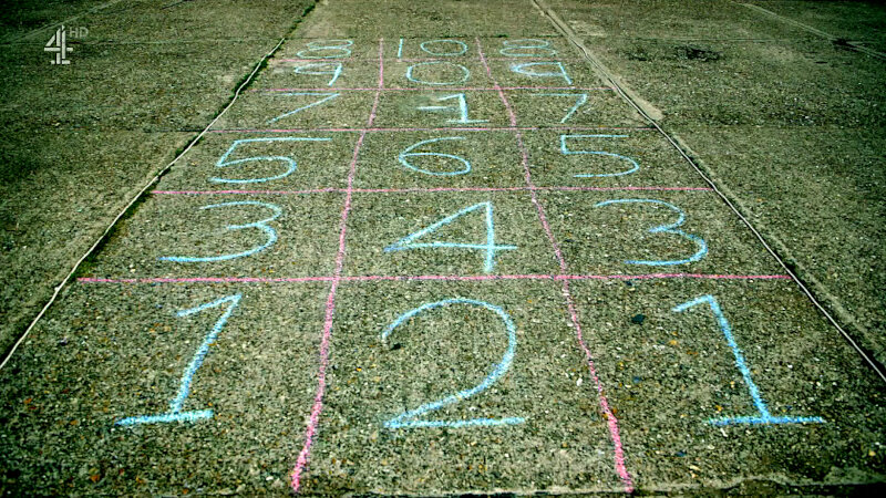A 6 by 3 grid of squares drawn in chalk on pavement. Each square has a number written in it. A 6 by 3 grid of squares drawn in chalk on pavement. Each square has a number written in it.