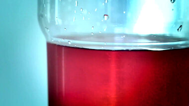 Close-up on a glass filled with red liquid.
