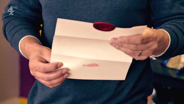 Chris Ramsey's hands holding an open task brief at reading height.