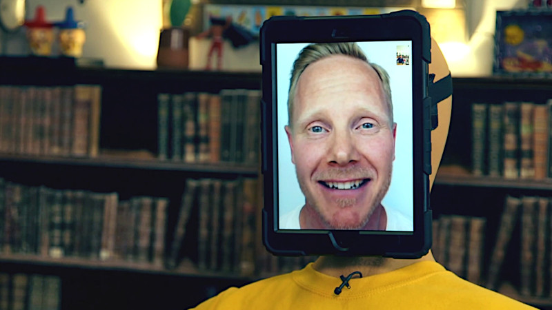 An iPad open to facetime with Fred the Swede is strapped to the face of a mannequin that is seated in the living room. An iPad open to facetime with Fred the Swede is strapped to the face of a mannequin that is seated in the living room.