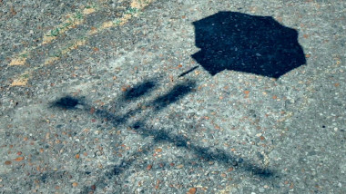 On the driveway, the shadow of a task brief suspended from a parachute is seen above the shadow of the Taskmaster house weathervane with the Taskmaster and Assistant silhouettes atop it.