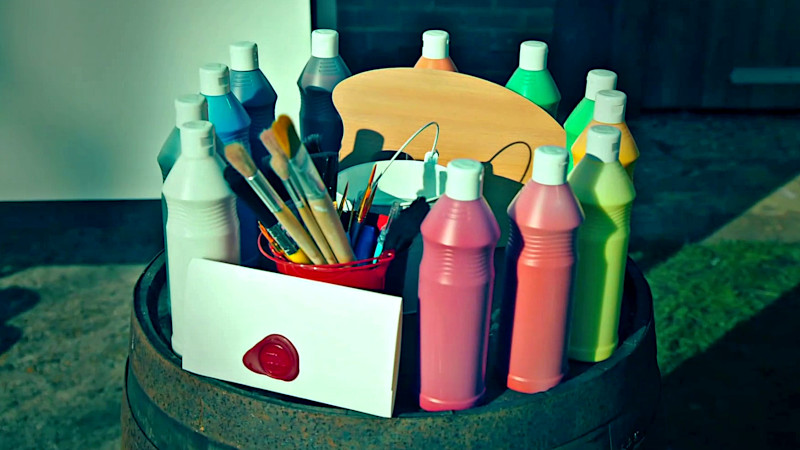 A sealed task brief rests on top of a barrel along with several bottles of paint, paintbrushes, two pails and a painter's palette. A sealed task brief rests on top of a barrel along with several bottles of paint, paintbrushes, two pails and a painter's palette.