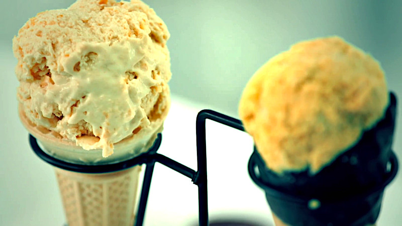 Two ice cream cones in a holder. Both ice creams are beige coloured. Two ice cream cones in a holder. Both ice creams are beige coloured.