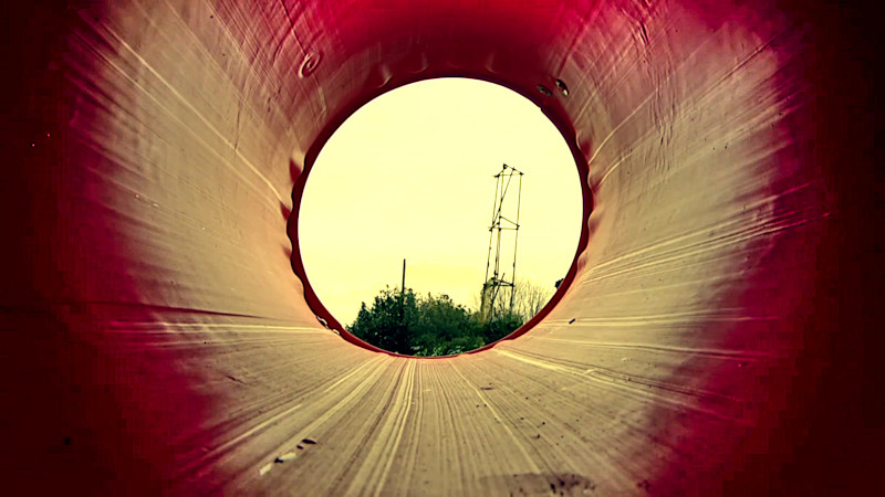 A view of the treetops and sky through a red rubber chute. A view of the treetops and sky through a red rubber chute.