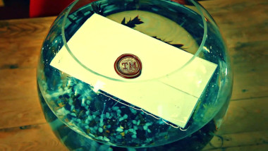 A sealed task brief floating in a fish bowl.