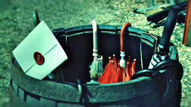 A sealed task brief poking out of a barrel full of umbrellas.