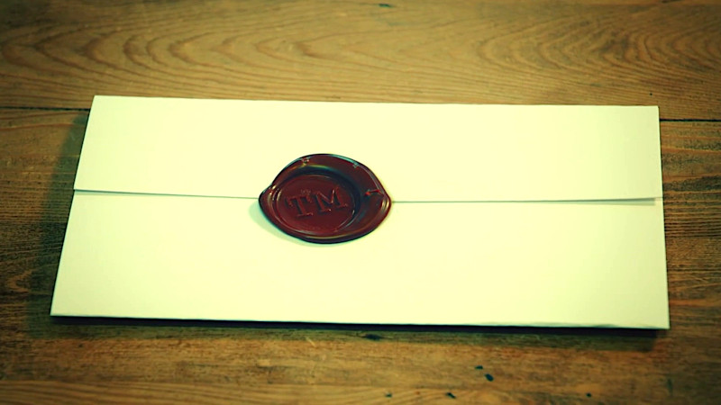 A sealed task brief on a wooden table. A sealed task brief on a wooden table.