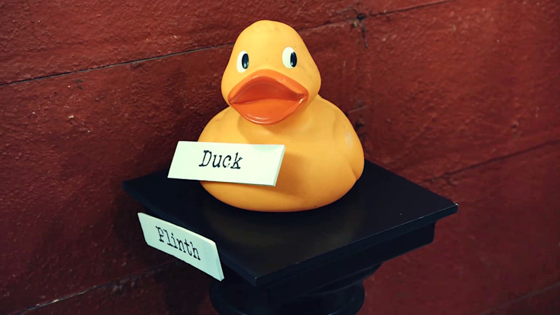 A duck on a plinth, with self-referring labels on each of them. A duck on a plinth, with self-referring labels on each of them.