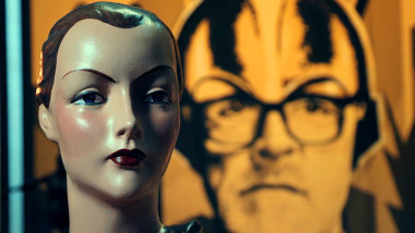 A bust of a mannequin head with the Taskmaster's portrait in the back.