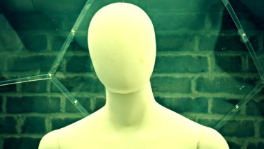 A close-up of the head and shoulders of a featureless white mannequin in the geodesic dome in the Taskmaster house garden.