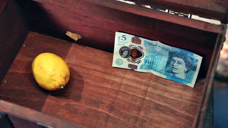 A lemon and a five pound note inside the box. A lemon and a five pound note inside the box.